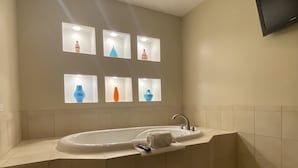 A modern bathroom with a freestanding bathtub, a sink, and a mirror. - Grand Hotel  (Spring City)