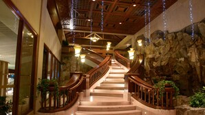 A grand staircase with wooden railings, marble steps, and decorative lighting. - Nexus Resort & Spa Karambunai (Kota Kinabalu)