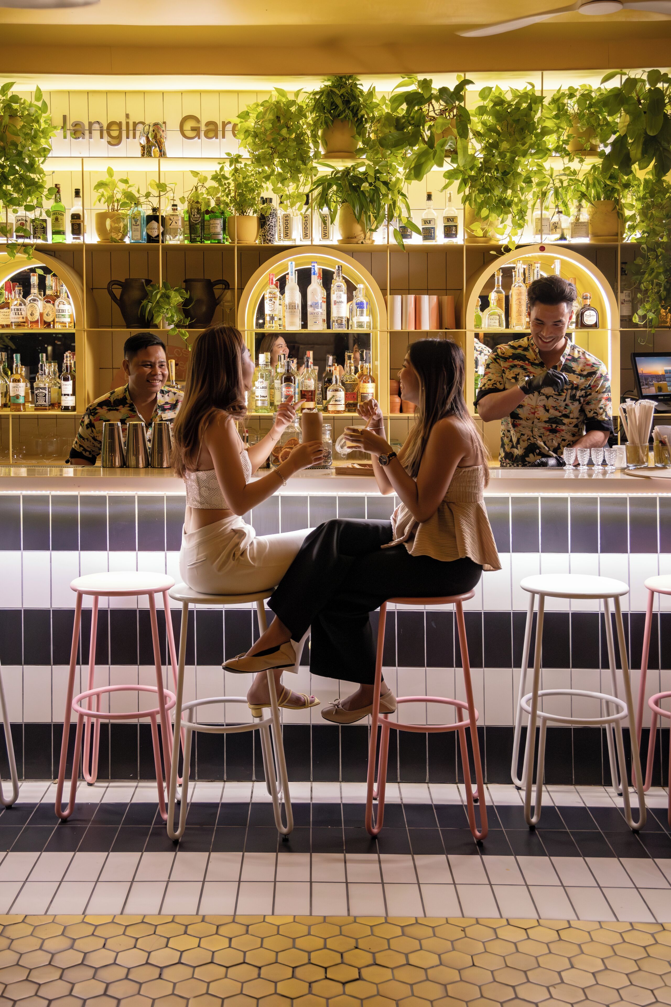 Zona de bar con taburetes, mostrador con botellas y un cartel que dice 'Hangin' Gar'.
