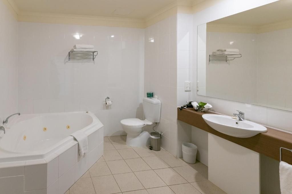 A modern bathroom with a bathtub, toilet, and sink.