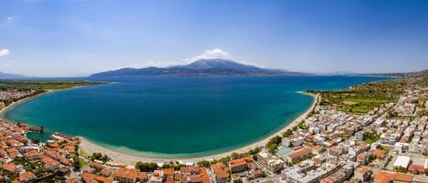 Un pueblo costero con una gran bahía, una montaña al fondo y una combinación de edificios residenciales y comerciales.