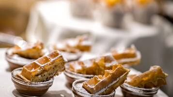 A close-up of waffles in small bowls with powdered sugar.