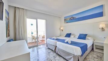 A hotel room with two beds, a balcony, and a painting of a mountain landscape.
