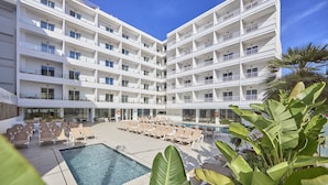 A multi-story hotel with a pool area, lounge chairs, and a large plant. - Hotel Ilusion Calma & Spa (Palma de Mallorca)