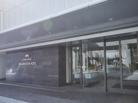 A modern building with a glass entrance and a sign reading "WHG Kansas Airport Washington Hotel".. Kansai Airport Washington Hotel
