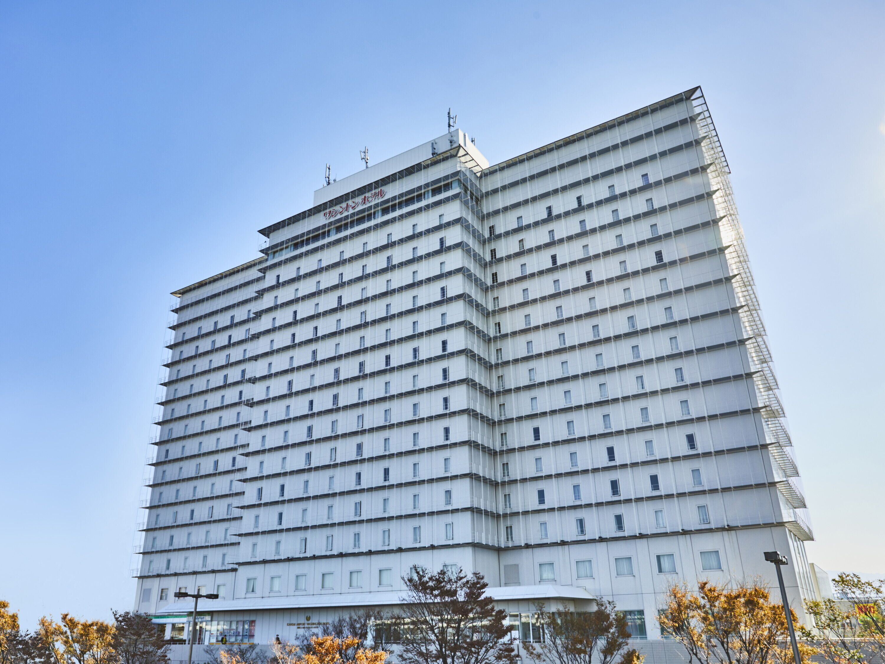 Un hotel de varios pisos con una fachada enrejada, numerosas ventanas y techo plano.