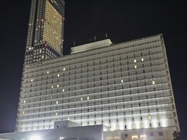 A high-rise building with a grid-like facade, multiple floors, and evenly spaced windows.