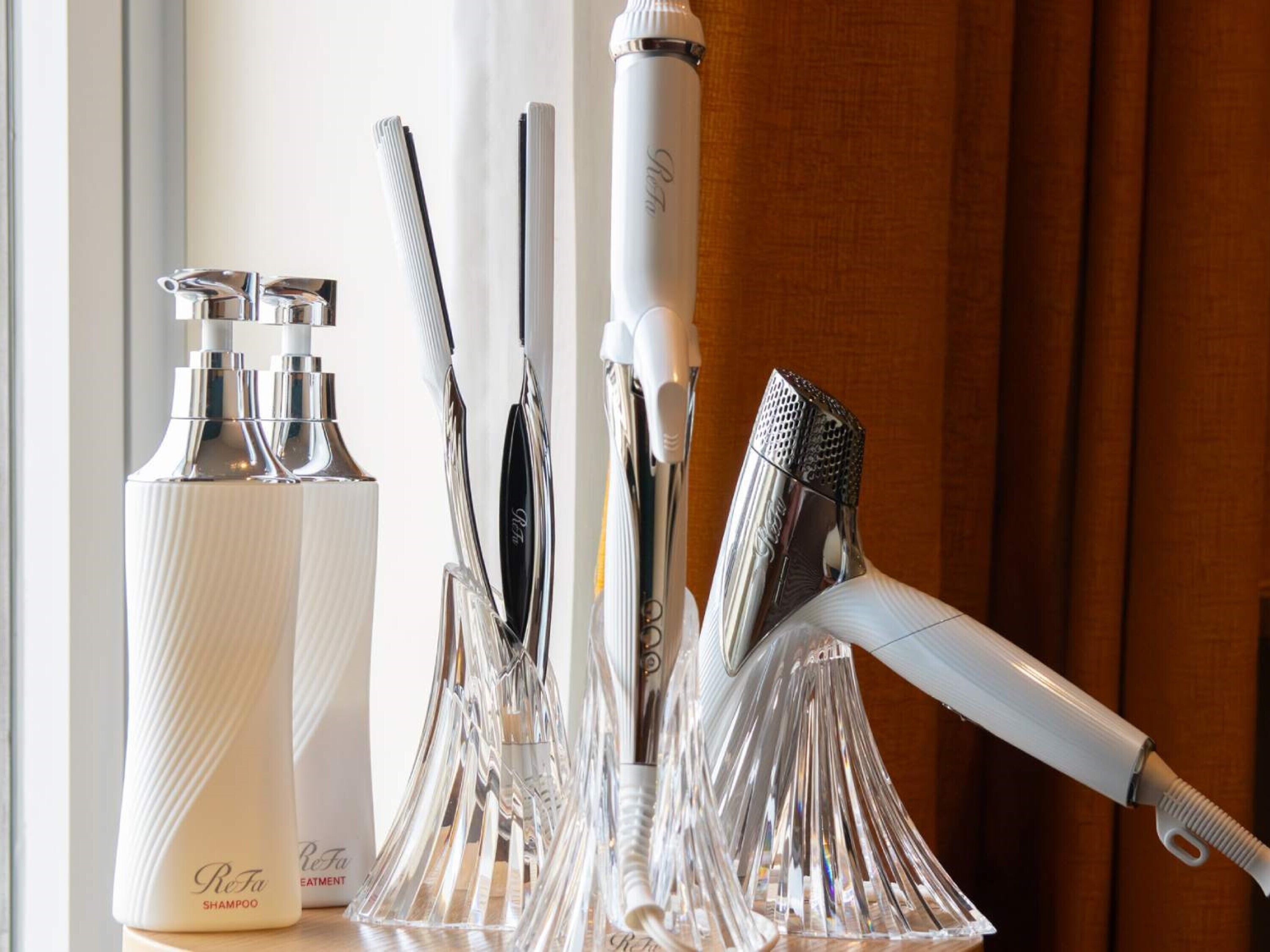 Un meuble-lavabo de salle de bain avec une bouteille de shampoing Refa, un rasoir et un porte-brosses à dents contenant plusieurs brosses à dents.