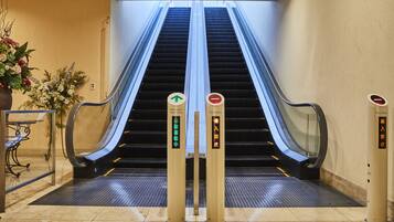 An indoor escalator with a "No Entry" sign and an "Automatic Operating" sign.