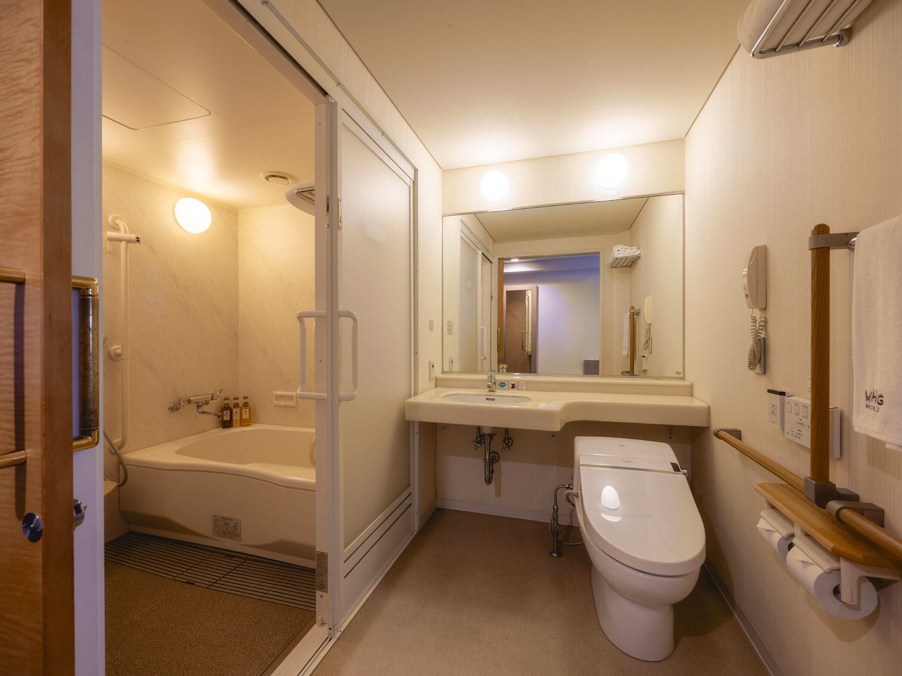 Un baño con bañera, inodoro, lavabo y espejo.