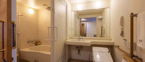 Un baño con bañera, inodoro, lavabo y espejo.
