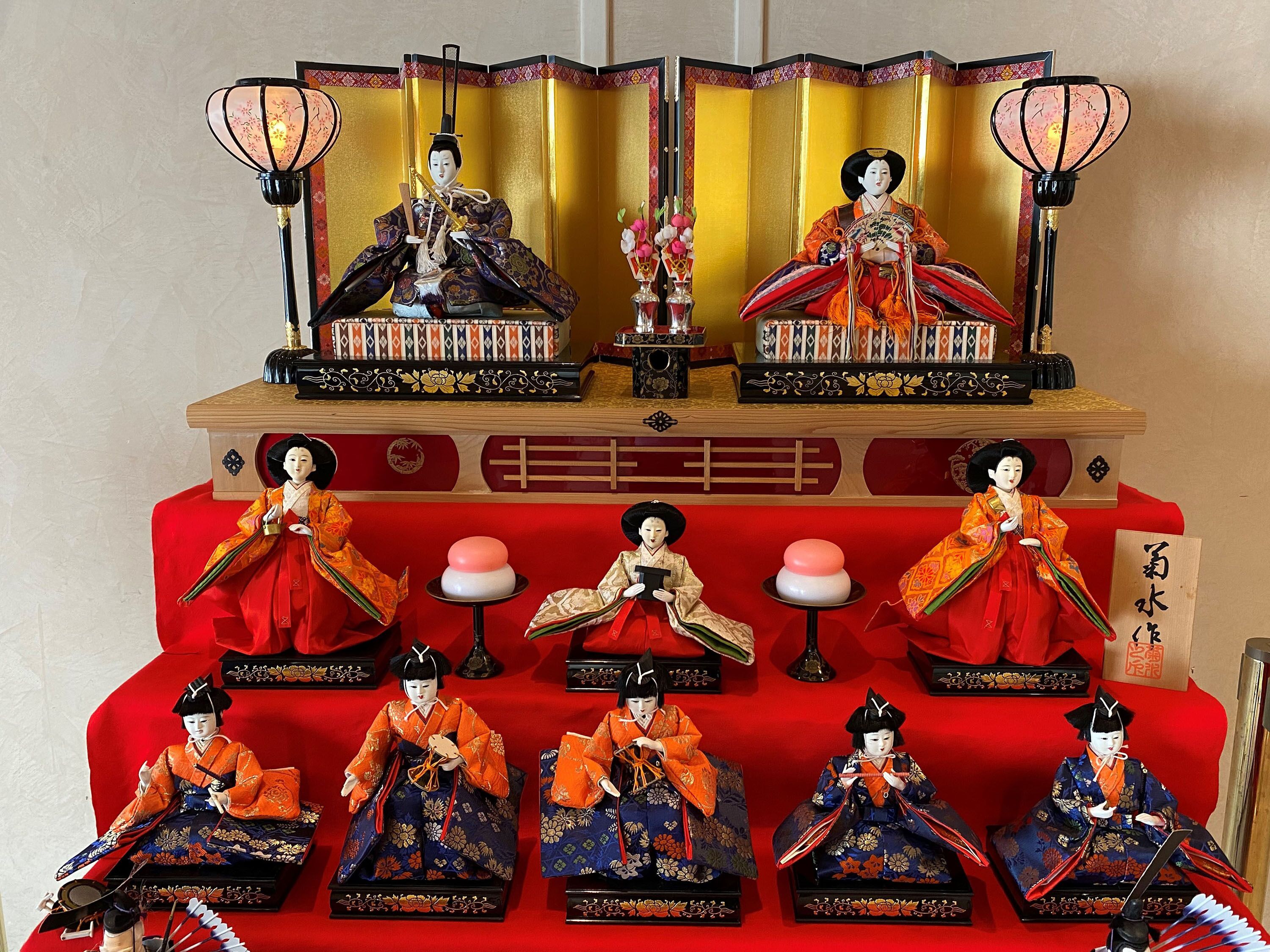 Ett traditionellt japanskt rum med tatamimattor på golvet, ett lågt träbord och en röd kudde.