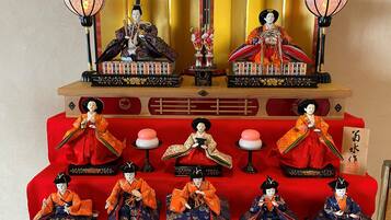 Une pièce de style japonais traditionnel, avec un sol recouvert de tatamis, une petite table en bois et un coussin rouge.