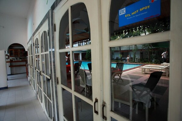 A hotel corridor with a pool area visible through the glass doors. - Vansana Vientiane - Ban Phonthan (Vientiane)