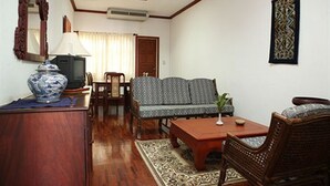 A living room with a sofa, a coffee table, a TV, and a decorative mirror. - Vansana Vientiane - Ban Phonthan (Vientiane)