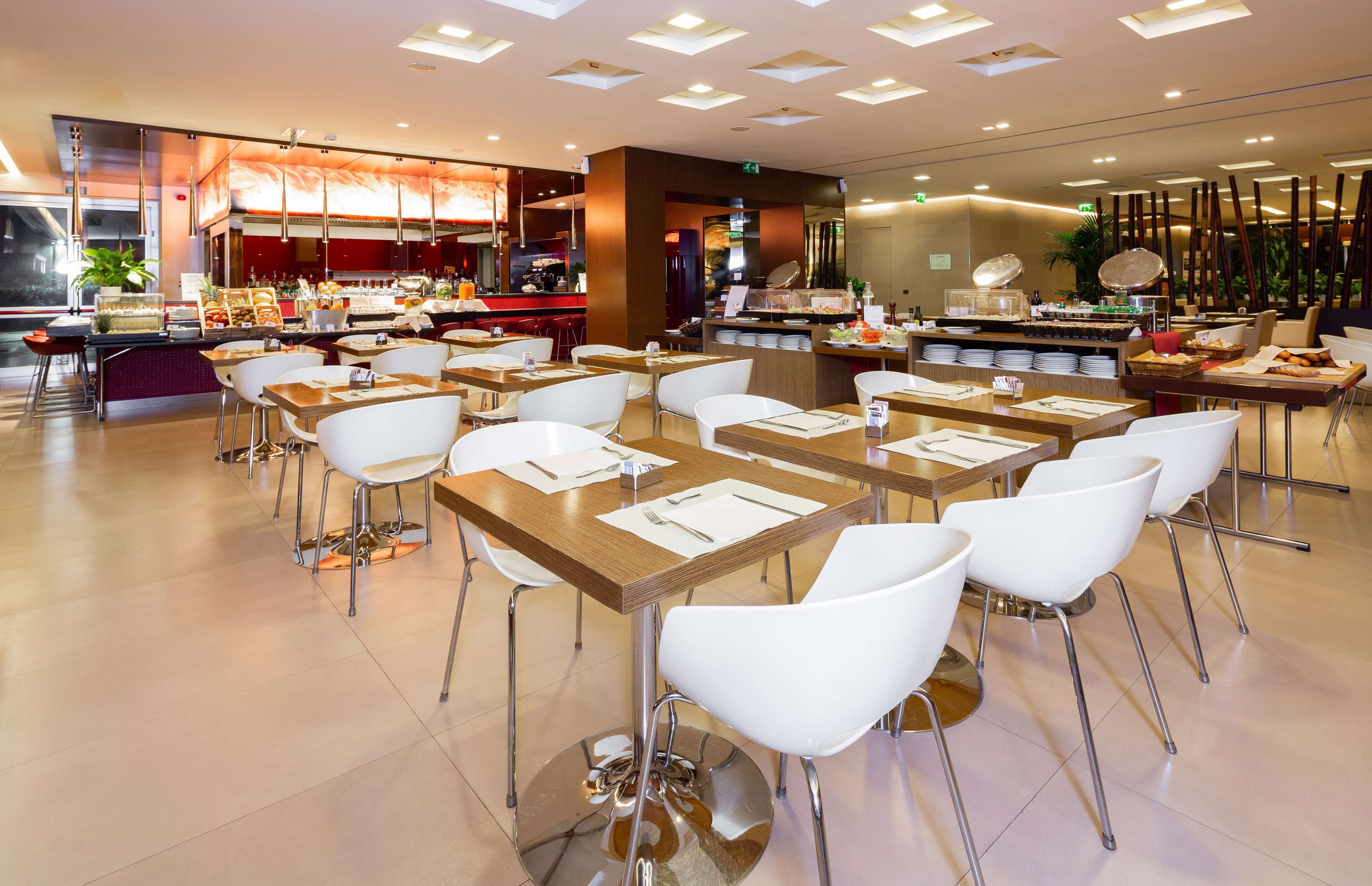 Ein modernes Restaurant mit mehreren Tischen, Stühlen, einer Selbstbedienungsbereich und einer Bar.