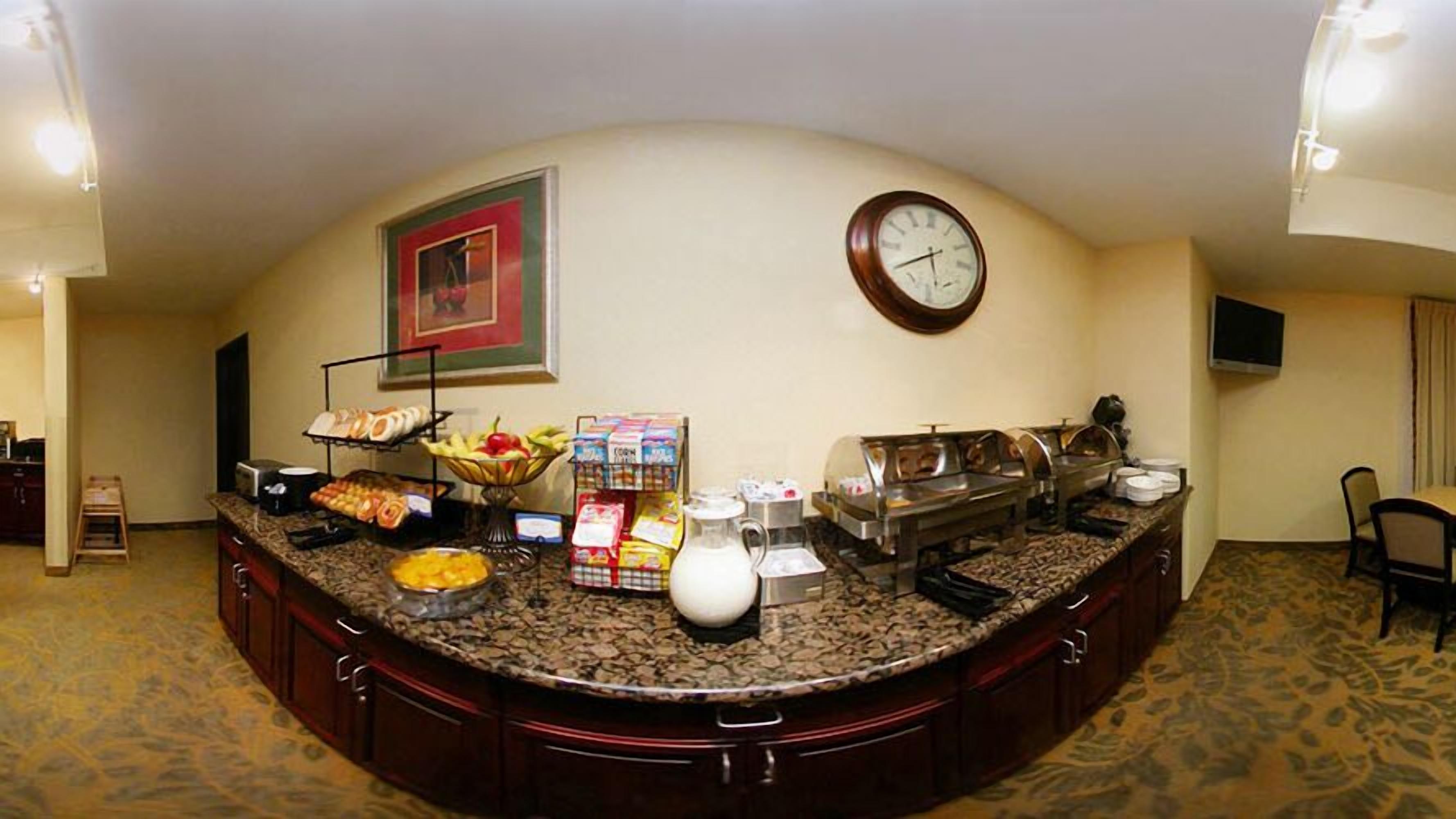 A buffet setup with various food items and a clock on the wall.