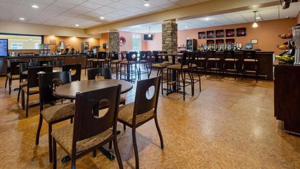 A hotel lobby with multiple seating areas, a bar, and a projection screen in the background. - Crandon Inn and Suites (Crandon)