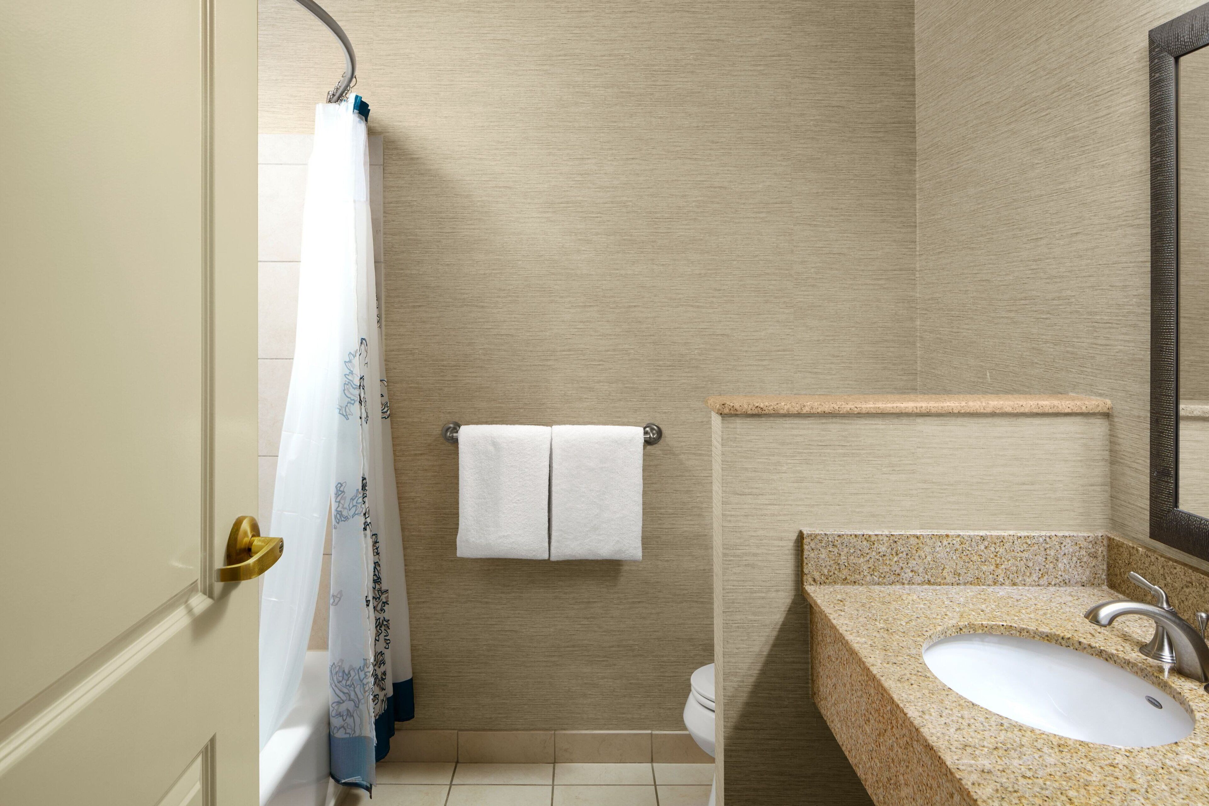 A bathroom with a bathtub, a sink, and a towel rack.