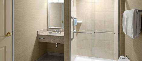 Une salle de bain moderne dotée d’une douche à parois de verre, d’un lavabo et de toilettes.