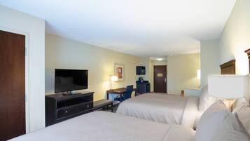 A hotel room with two beds, a TV, a desk, and a chair.