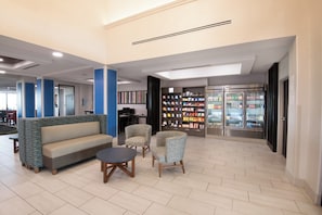 A lobby area with seating, a vending machine, and a refrigerator stocked with beverages. - Holiday Inn Express & Suites Yuma by IHG (Yuma)