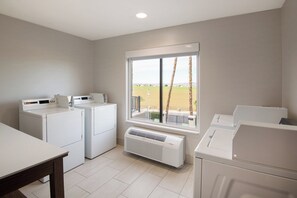 A laundry room with a large window, a washing machine, a dryer, and a heater. - Holiday Inn Express & Suites Yuma by IHG (Yuma)