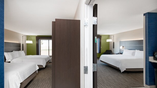 Habitació d'hotel amb dos llits, un escriptori i una cadira.