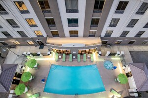 Una piscina al aire libre, sillones reclinables de piscina
