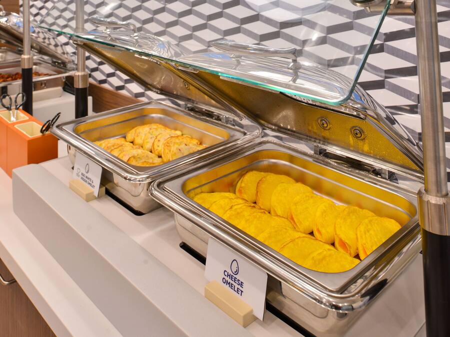 Buffet com seções identificadas para omeletes e omeletes com queijo.