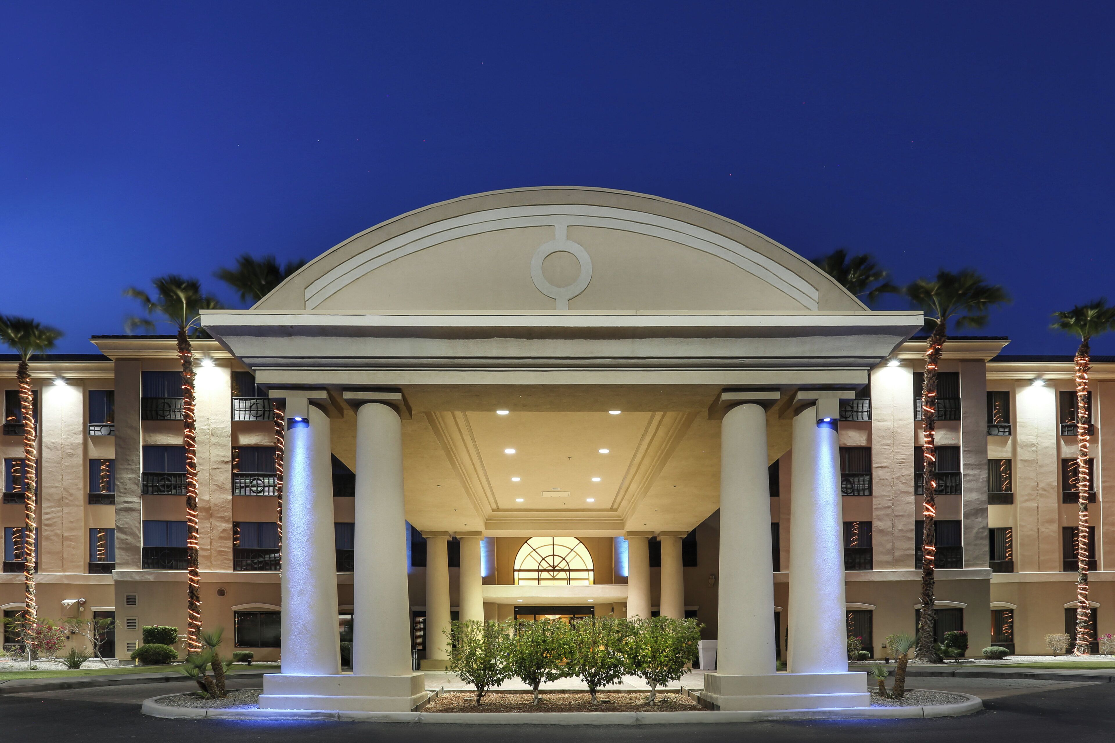 A hotel entrance with a central archway, columns, and a symmetrical facade.