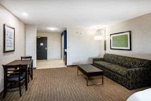 A hotel room with a dining table, chairs, a sofa, a coffee table, and a lamp. - Holiday Inn Express & Suites Yuma by IHG (Yuma)