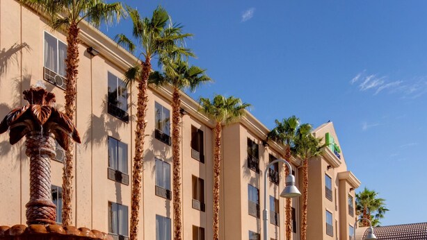 A hotel with a fountain, palm trees, and a clear blue sky. - Holiday Inn Express & Suites Yuma by IHG (Yuma)