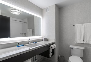 A modern bathroom with a large mirror, a sink, a toilet, and a towel rack. - Holiday Inn Express & Suites Yuma by IHG (Yuma)