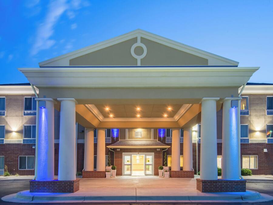 A hotel entrance with a covered walkway, columns, and a brick facade.