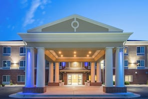 A hotel entrance with a covered walkway, columns, and a brick facade.
