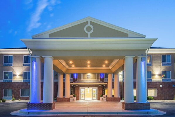 A hotel entrance with a covered walkway, columns, and a brick facade.