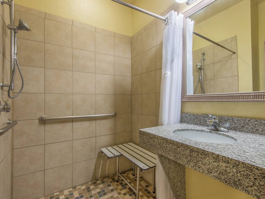 A bathroom with a shower, a sink, and a mirror.