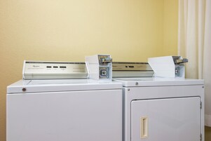 Two stacked washing machines with a control panel on top.