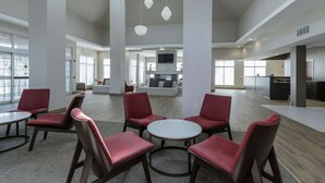 A spacious lobby with high ceilings, modern furniture, and a central seating area.