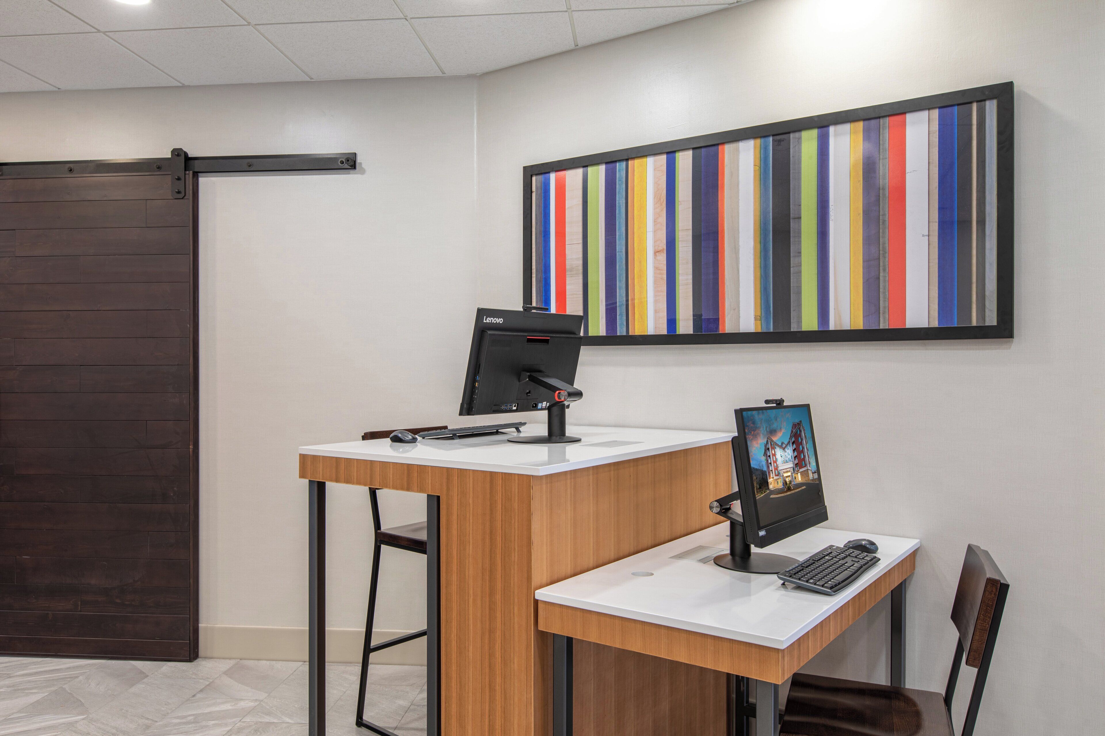 Una reception con una scrivania, un computer, una sedia e un quadro appeso al muro.