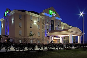 Un hôtel Holiday Inn Express doté d’une façade en pierre, de nombreuses fenêtres et d’une entrée bien éclairée.