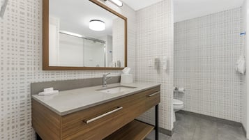 Une salle de bain moderne avec un meuble-lavabo en bois, un miroir, un évier et des toilettes.