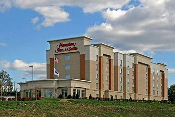 A Hampton Inn & Suites hotel building with a flat roof, multiple windows, and a flagpole with an American flag. - Hampton Inn & Suites Pittsburgh-Meadow Lands (Washington)