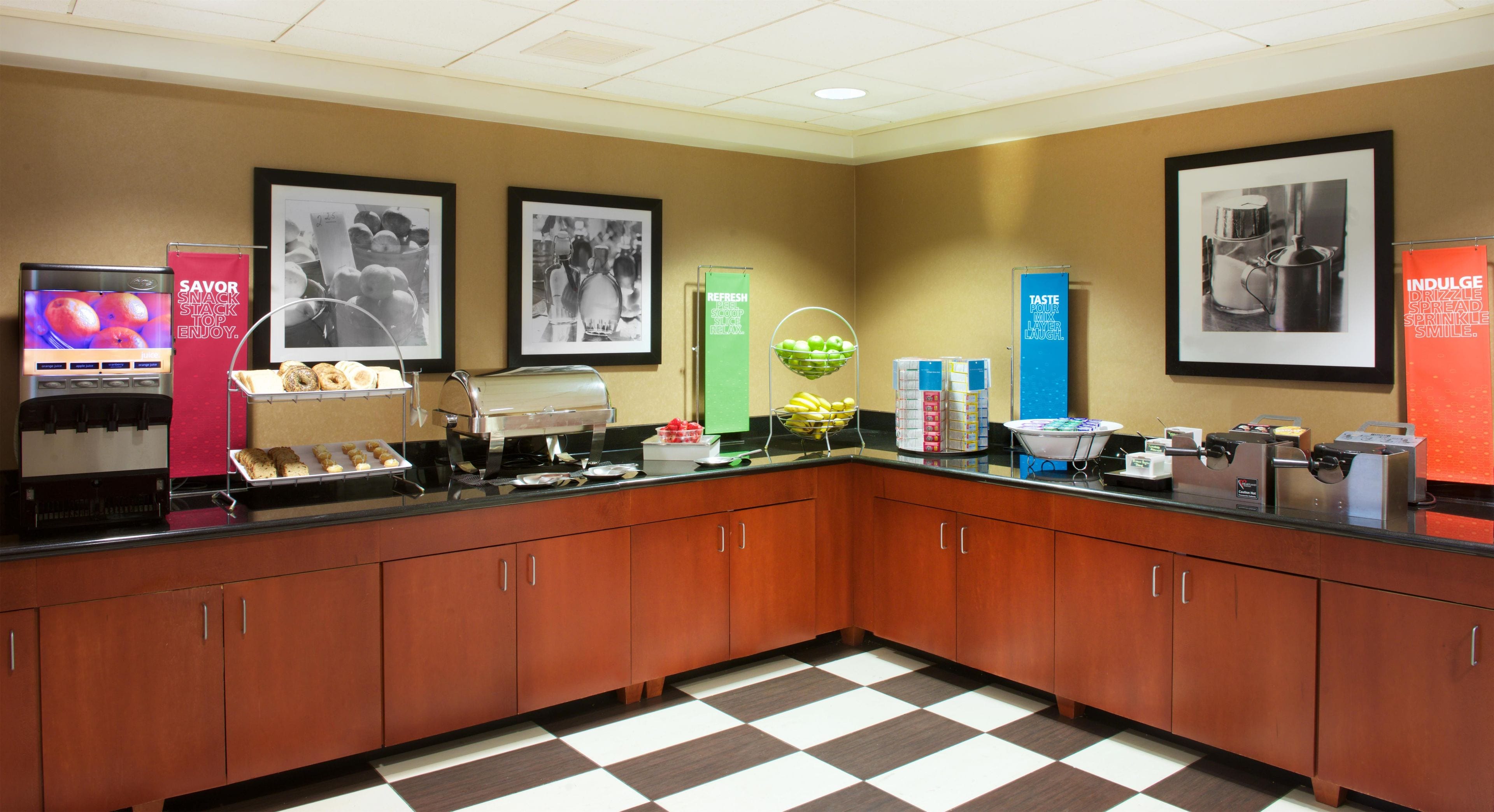 A hotel breakfast area with a self-serve station, a coffee machine, and various food options.