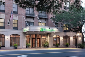 A Holiday Inn hotel with a brick facade, large windows, and a sign above the entrance. - Holiday Inn Savannah Historic District by IHG (Savannah)