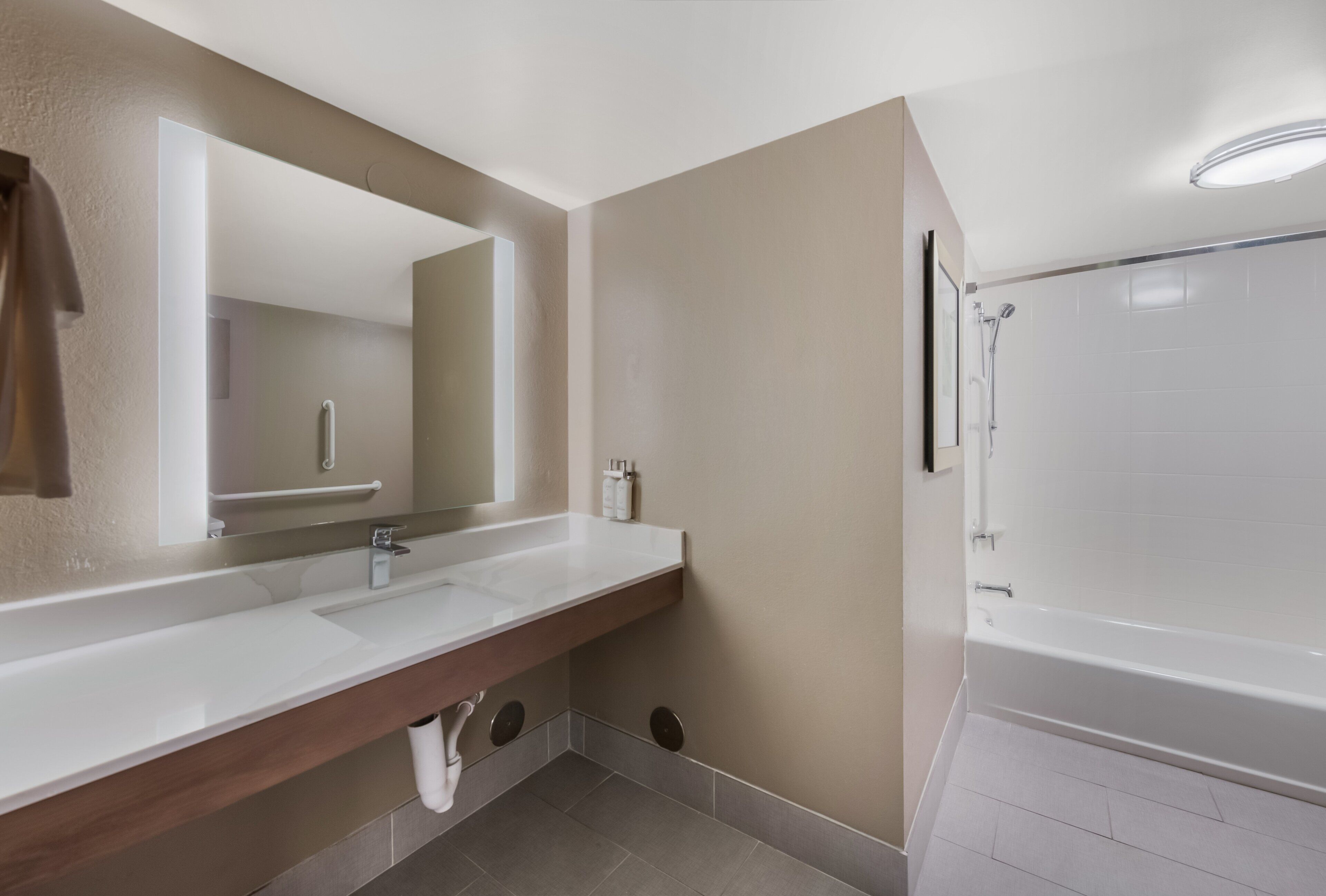 Un baño con tocador de doble lavabo, un espejo grande, ducha y inodoro.