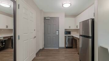 A modern kitchen with a stainless steel refrigerator, a built-in microwave, and a dishwasher.