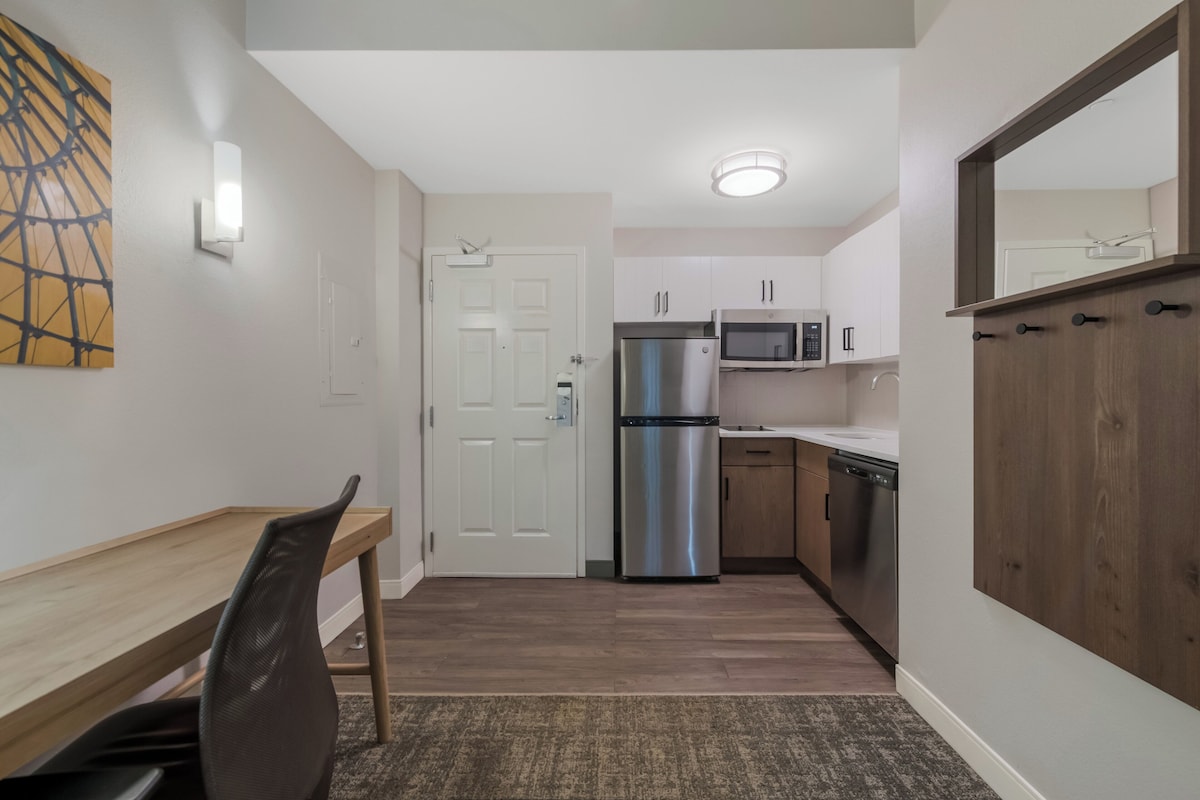 A compact kitchen with a refrigerator, microwave, and dishwasher.