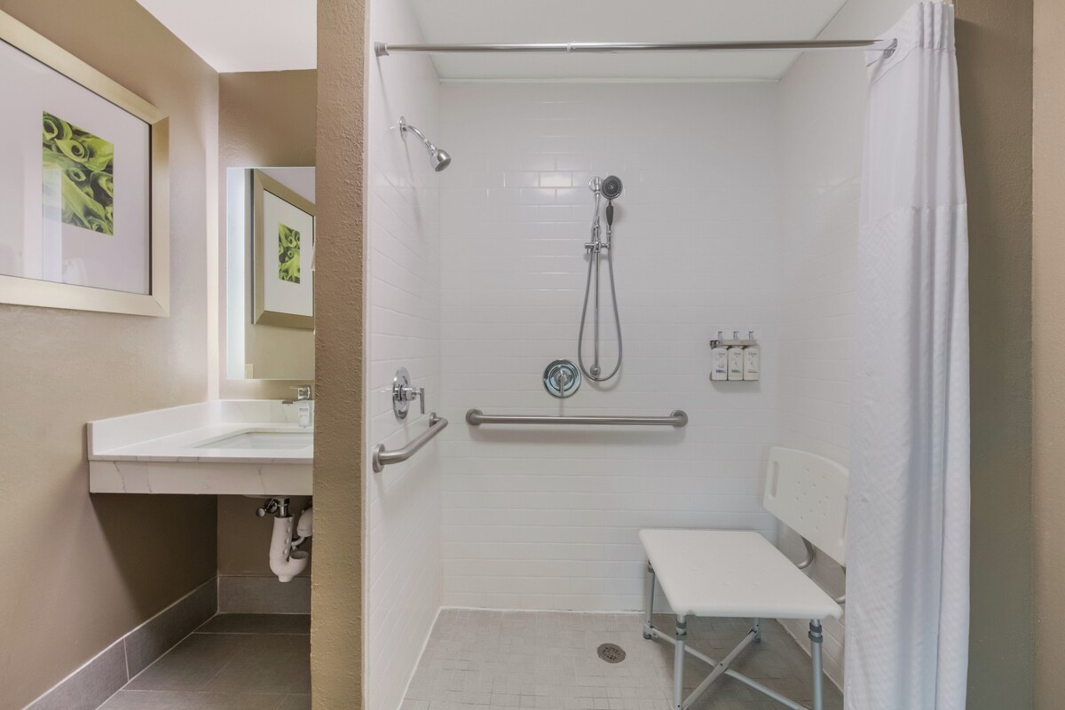 A bathroom with a shower, a sink, and a toilet.